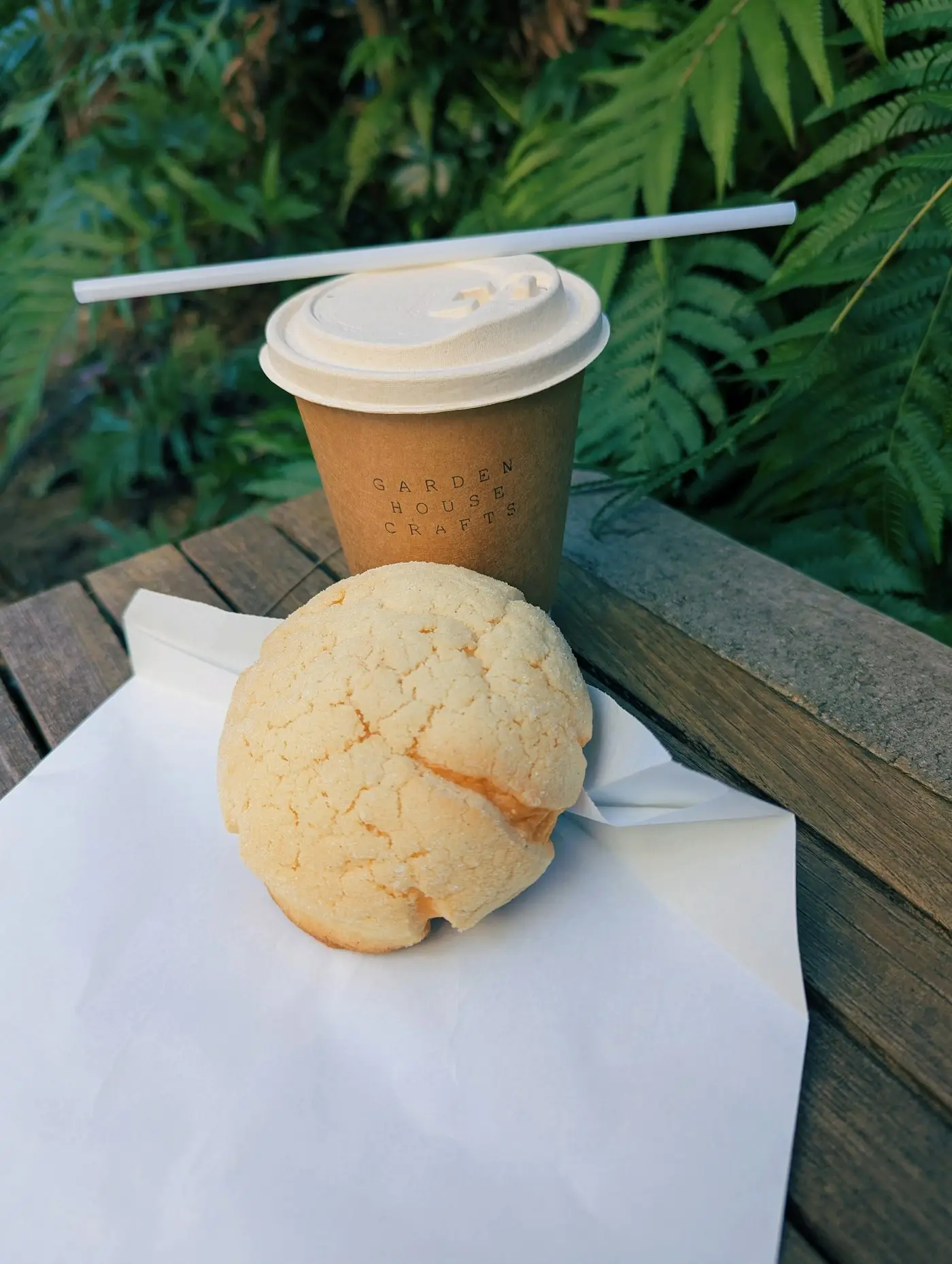 Un melon pan doré posé à côté d'un café