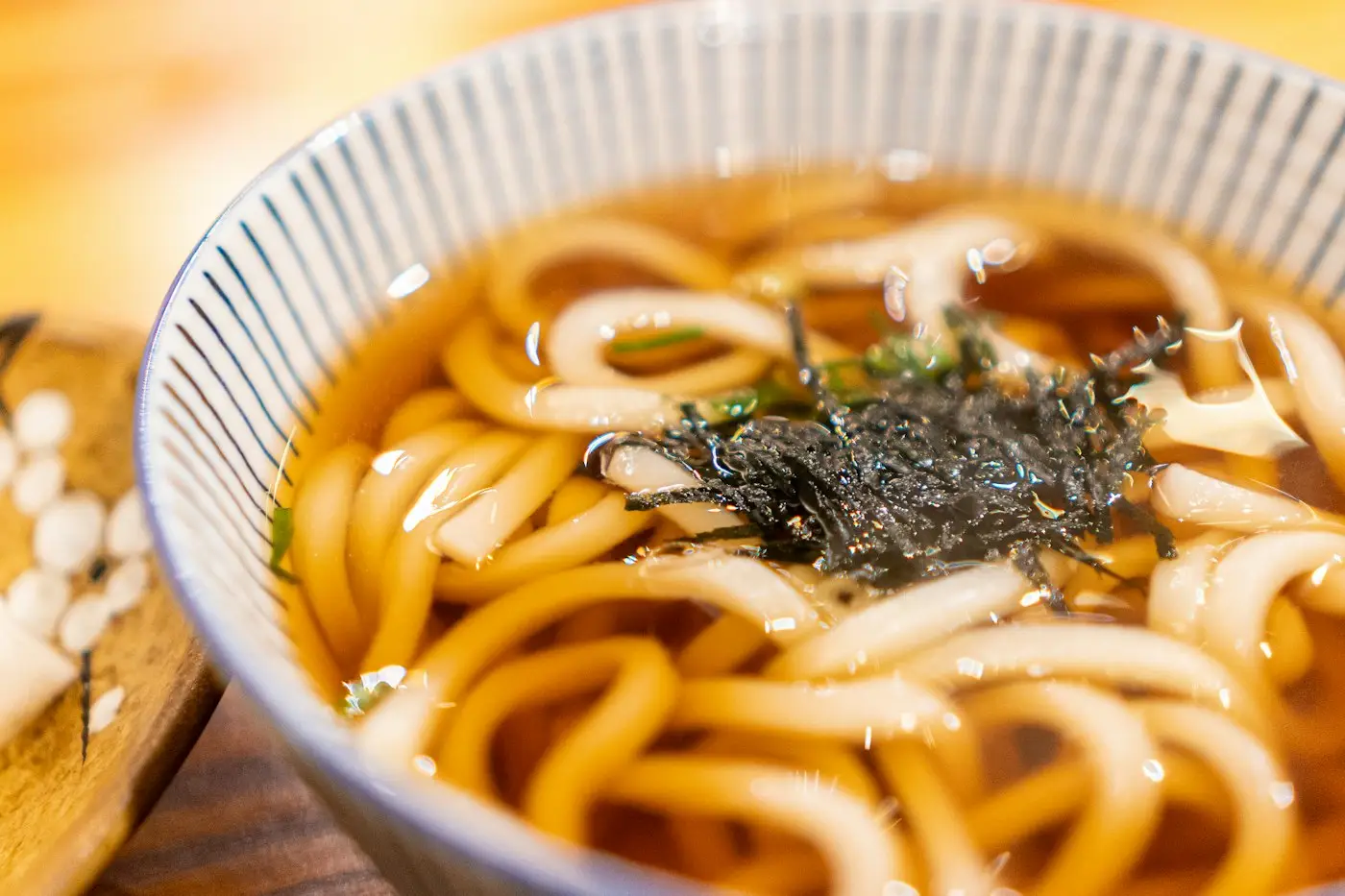 Un bol d'udon dans un bouillon clair, garni d'algues