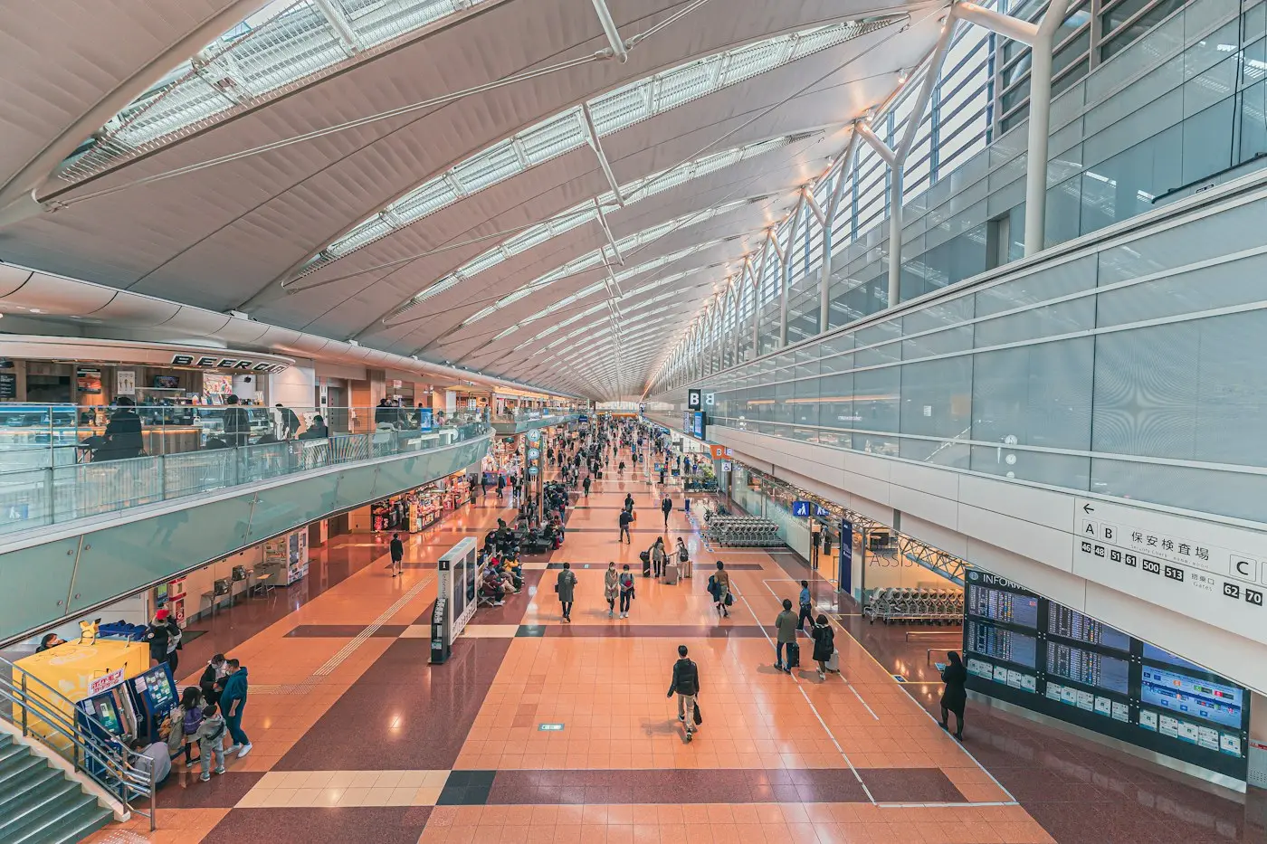 Des voyageurs dans le grand hall lumineux de l'aéroport de Haneda
