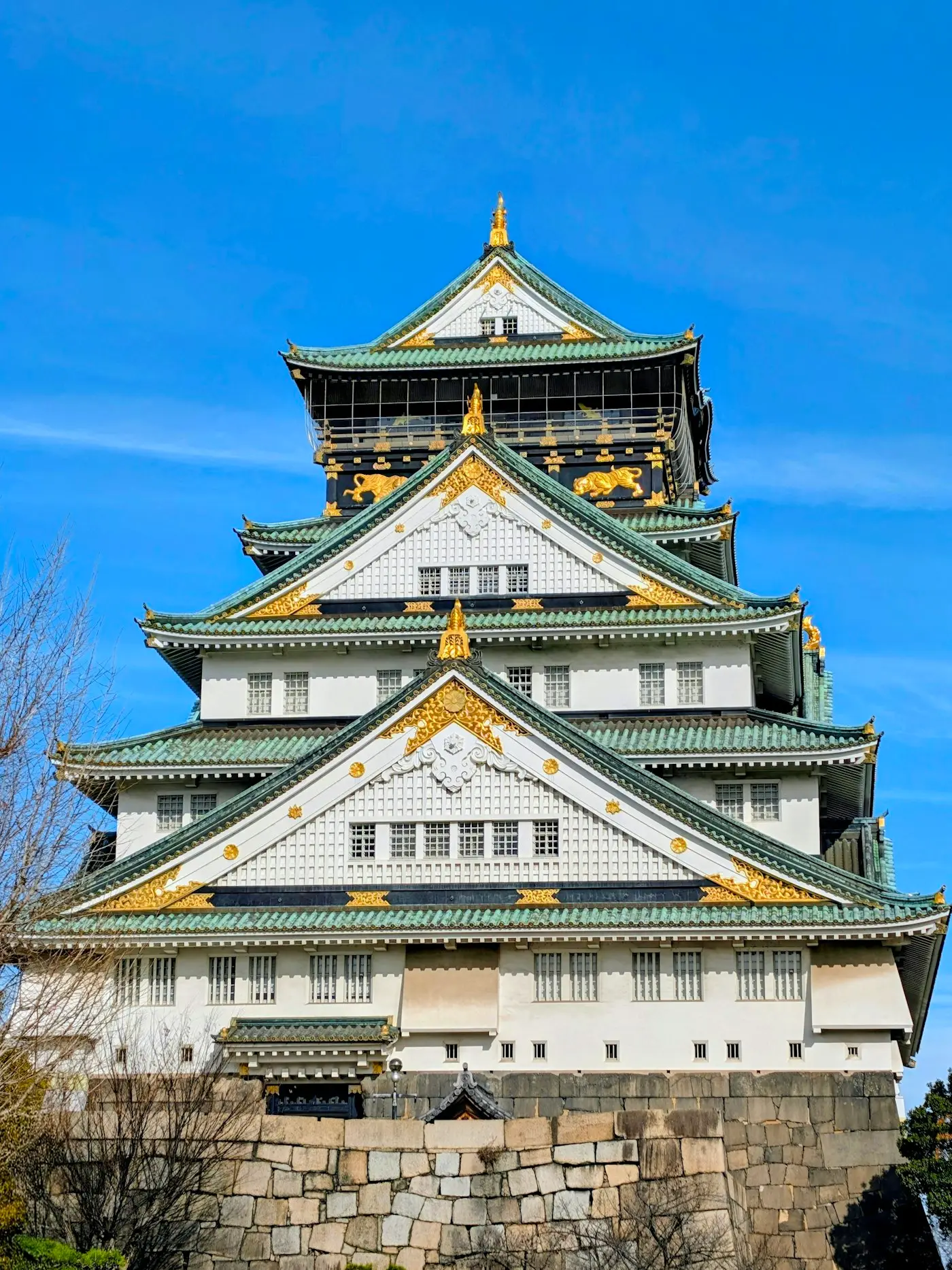 Le donjon blanc et or du château d'Osaka sous un ciel bleu